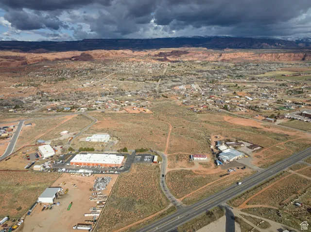 Aerial view of property and surrounding area featuring rural landscape and a mountainous background