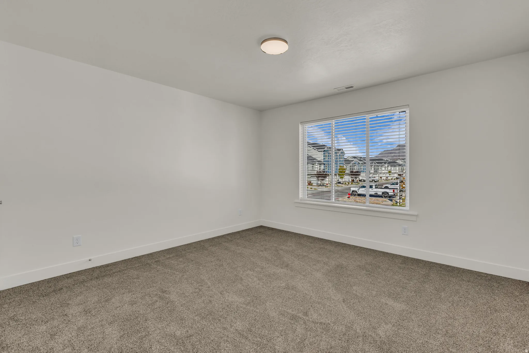 Carpeted spare room featuring baseboards