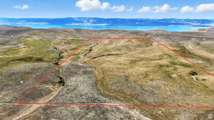 Aerial view of property and surrounding area with property parcel outlined and mountains