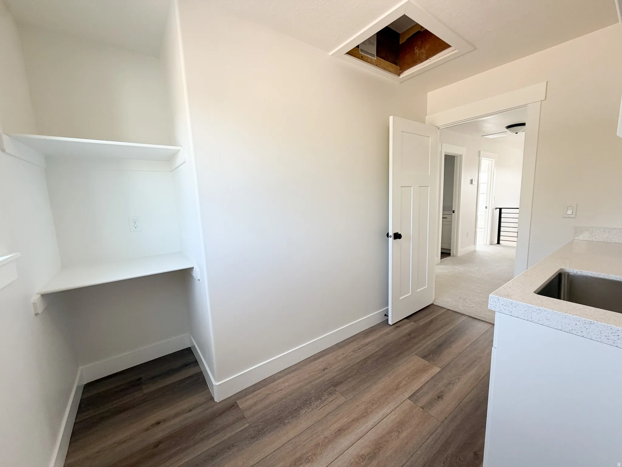 Utility space featuring wood-finish flooring and built-in shelving