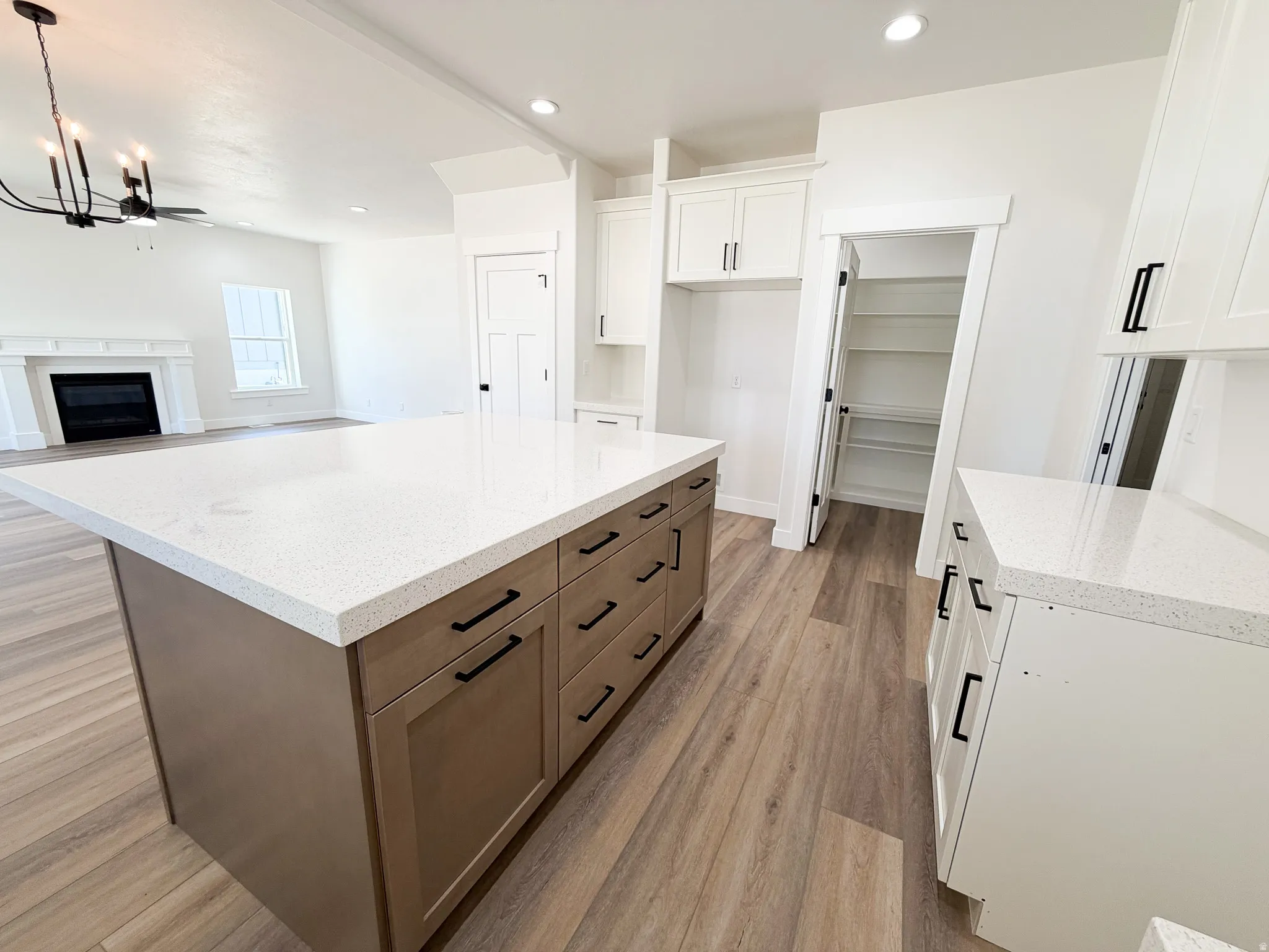 Kitchen featuring an expansive island with a light-colored countertop and two-tone cabinetry