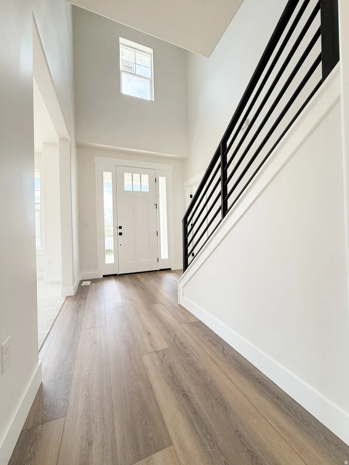 Two-story foyer featuring a prominent staircase with a contemporary horizontal railing