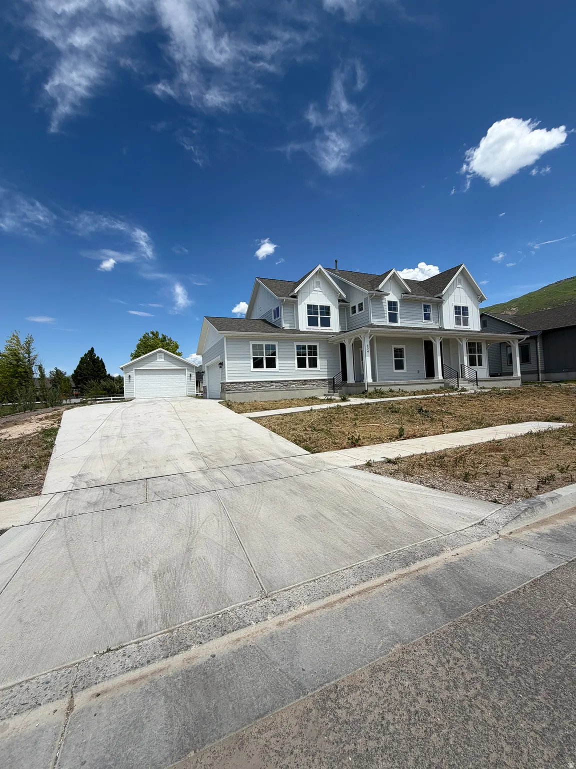 Contemporary two-story residence featuring light siding and a prominent front porch