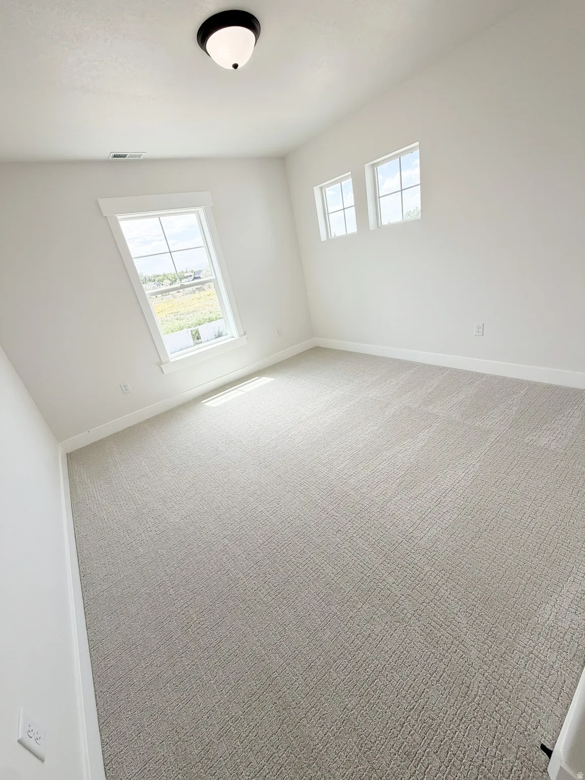 Room featuring light-toned patterned carpeting and white walls
