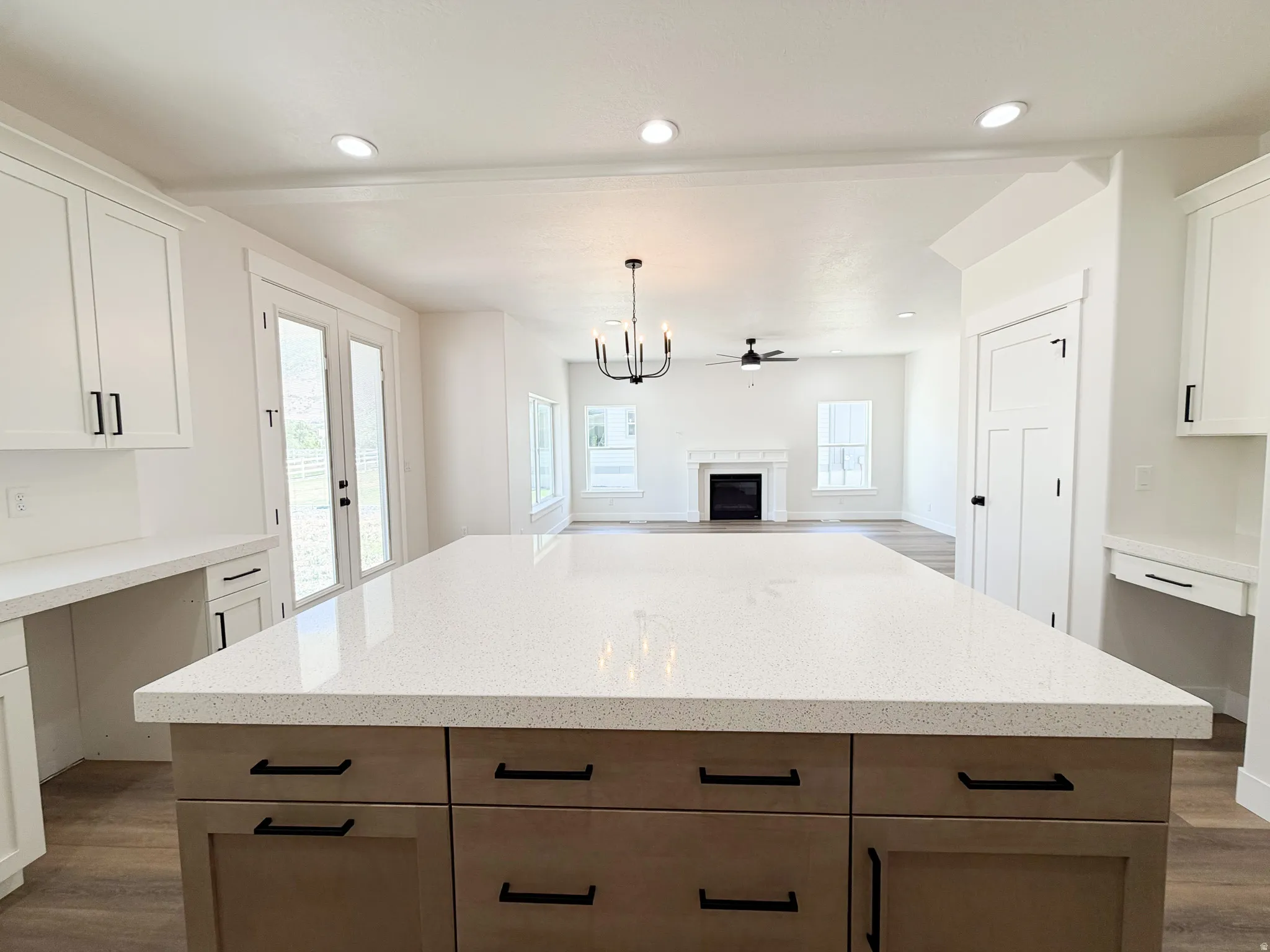 Spacious kitchen island with a light-toned countertop, complemented by wood-finish base cabinetry and matte black hardware