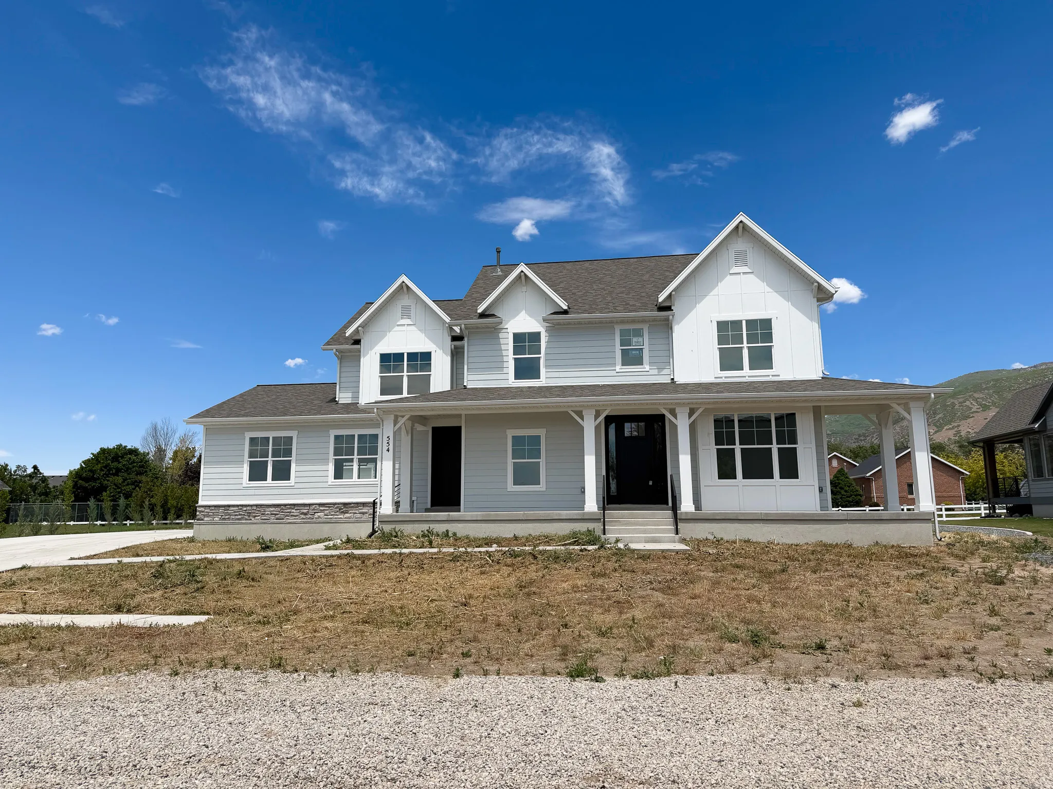 Modern farmhouse exterior with light gray siding and white trim