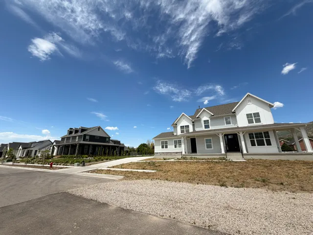 Two-story residence featuring light-colored siding and a covered front porch with white columns