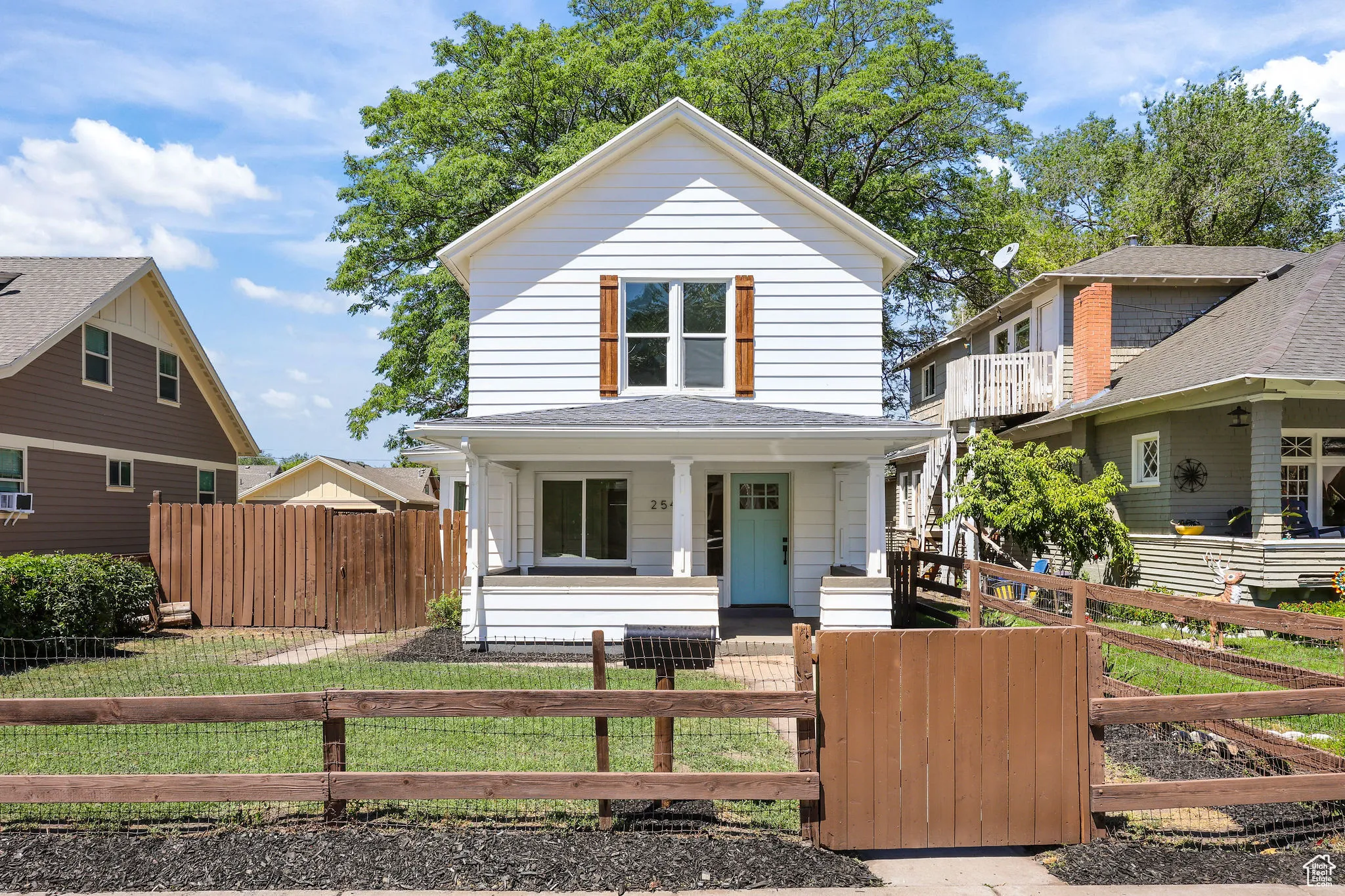 View of front of home featuring covered porch, a shingled roof, a gate, and a fenced front yard