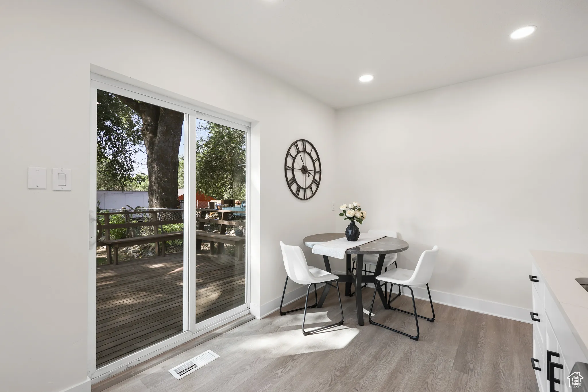 Dining area with light wood-style floors and recessed lighting