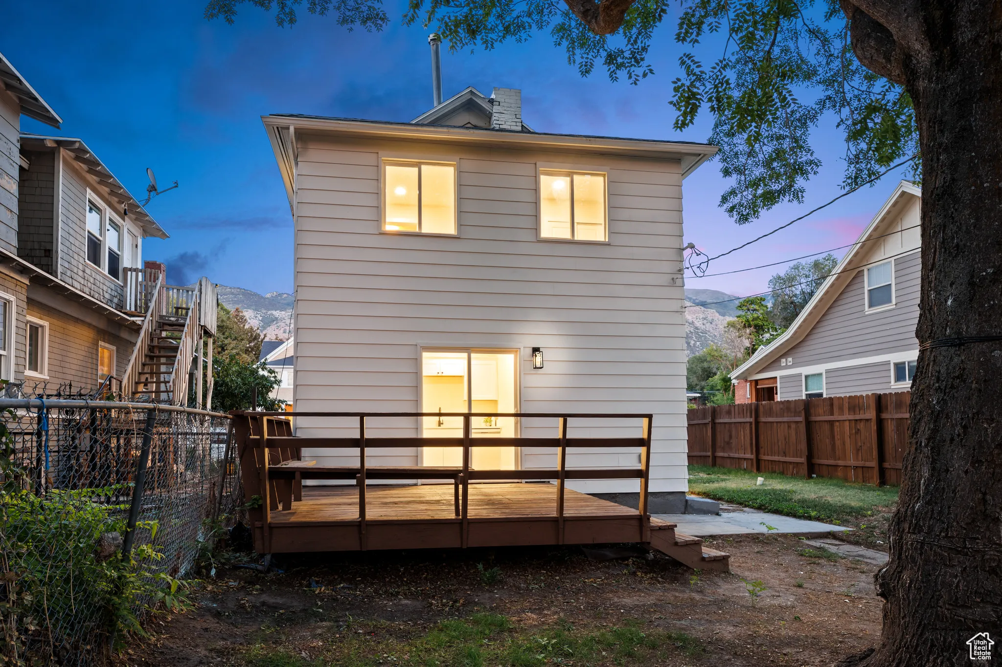 Back of property with a deck with mountain view and a fenced backyard