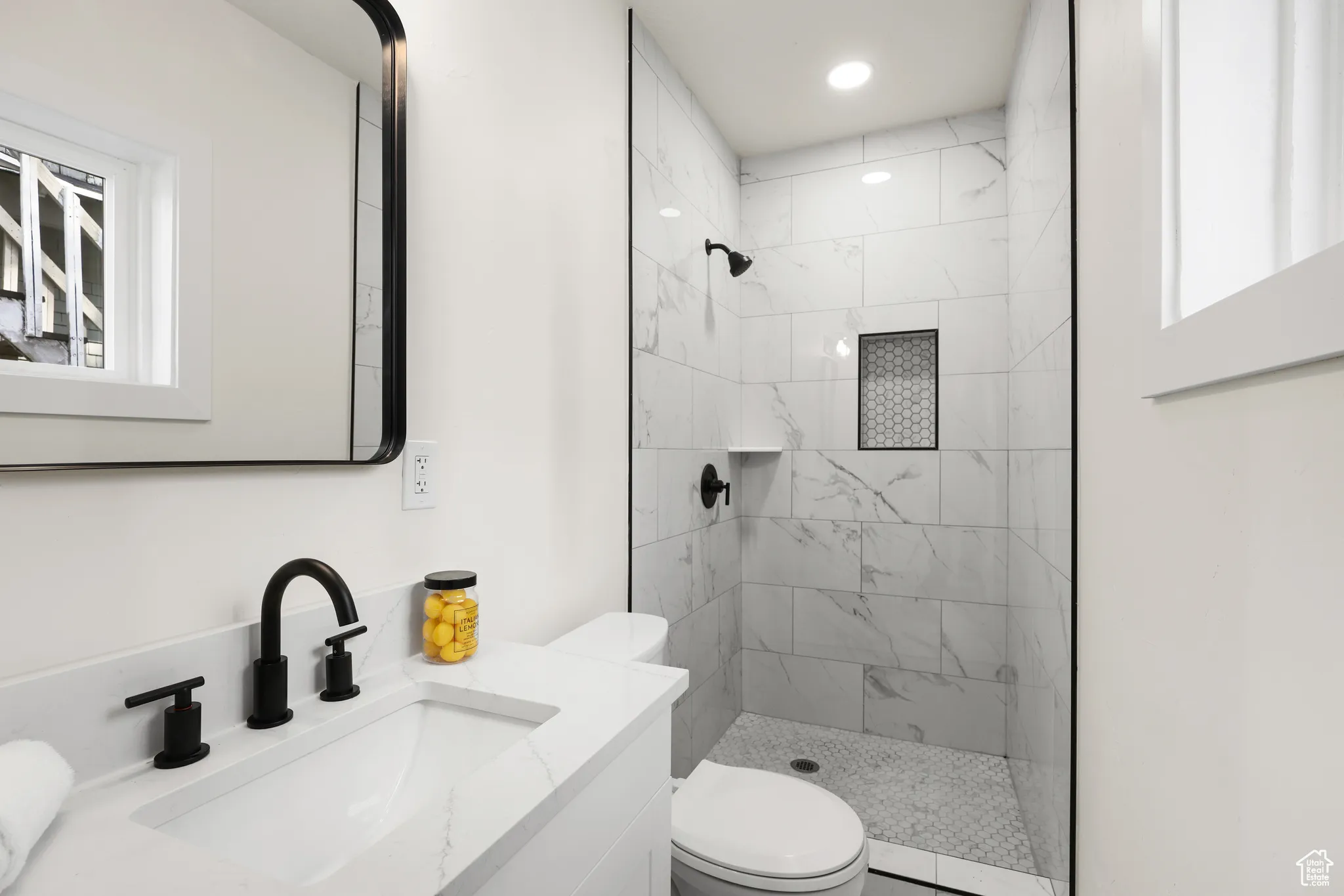 Full bathroom featuring vanity, a shower stall, and plenty of natural light