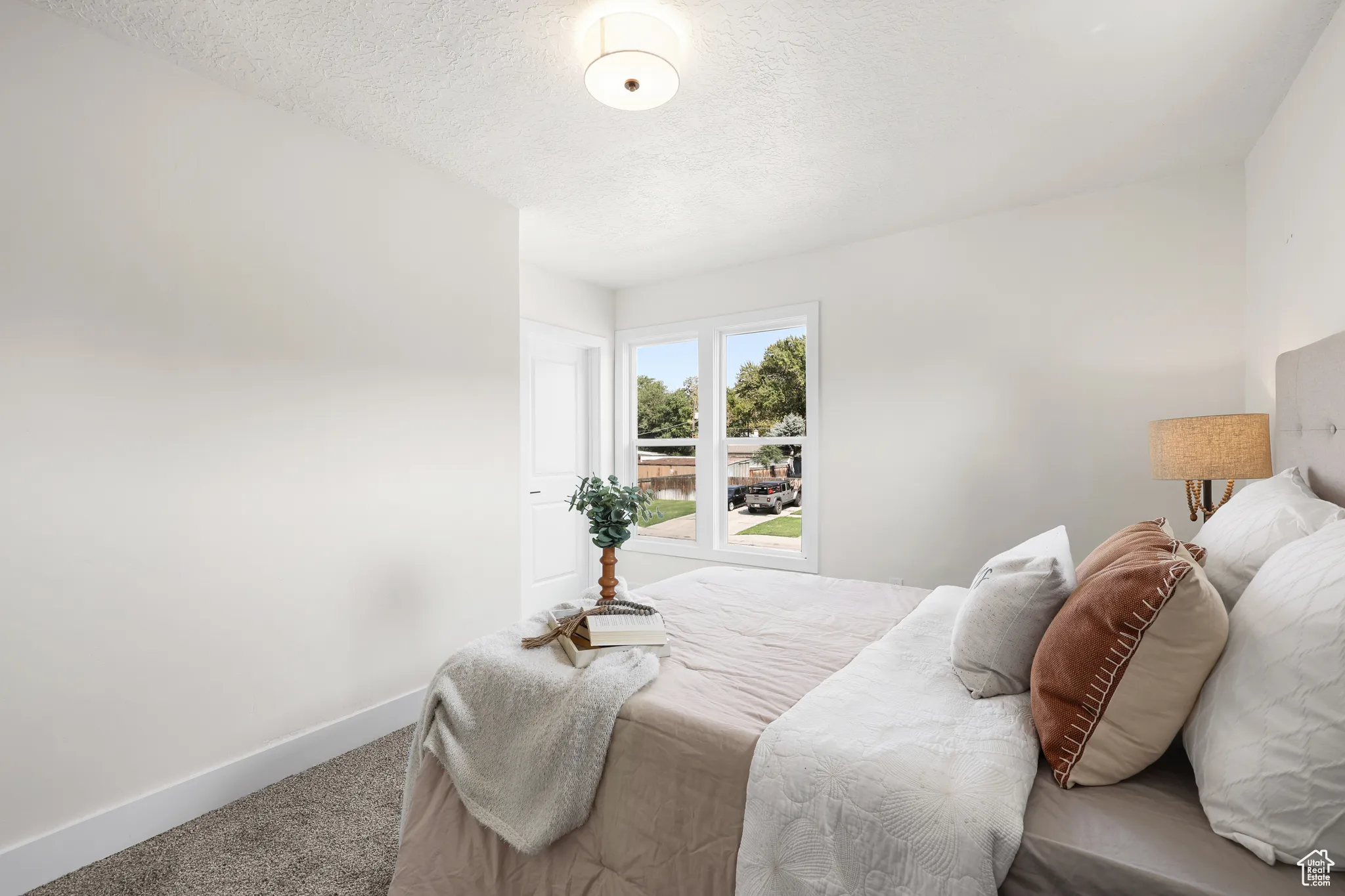 Carpeted bedroom featuring baseboards and a textured ceiling