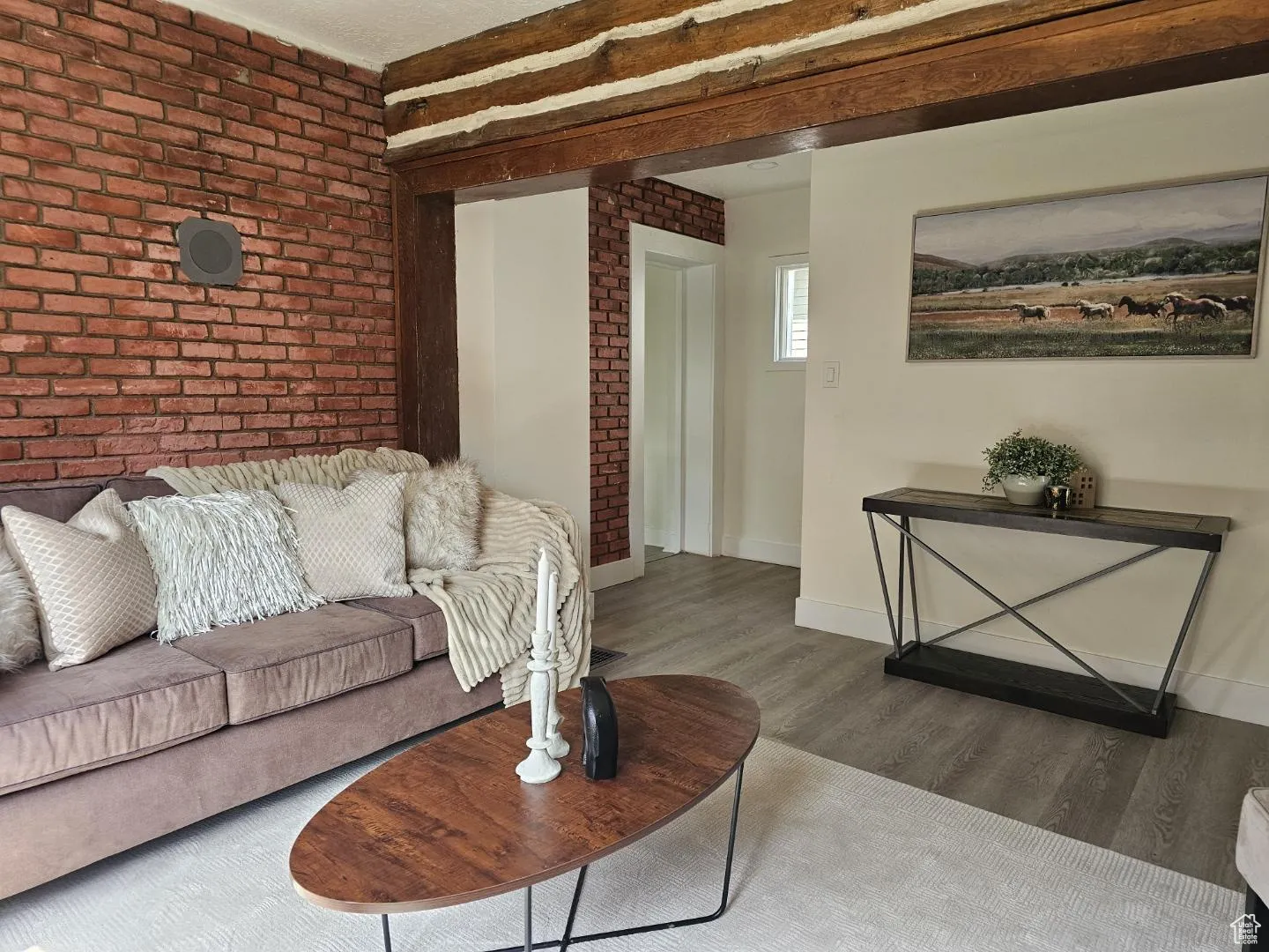 Living area with brick wall and wood finished floors