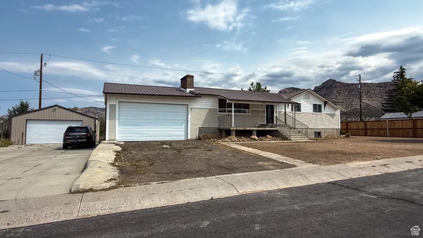 View of front of house with a metal roof and a chimney