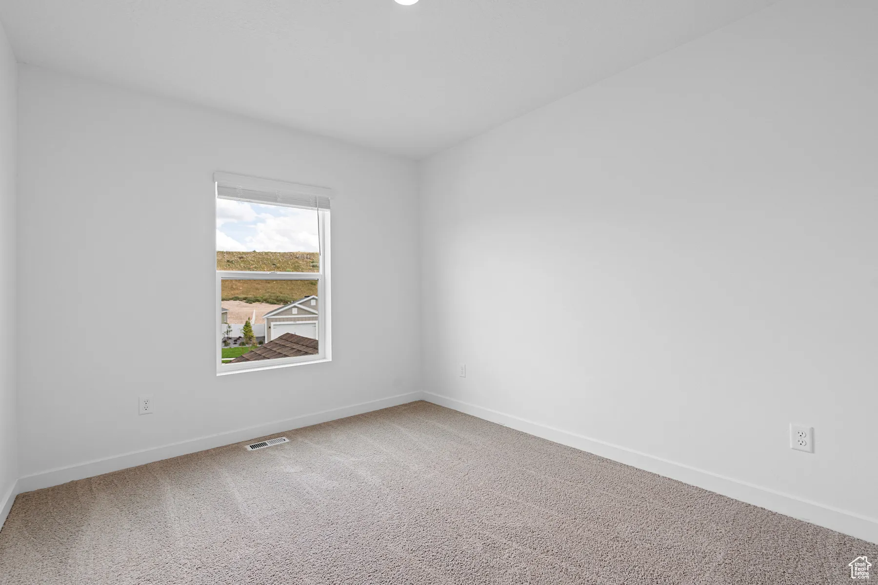 Spare room with carpet and baseboards