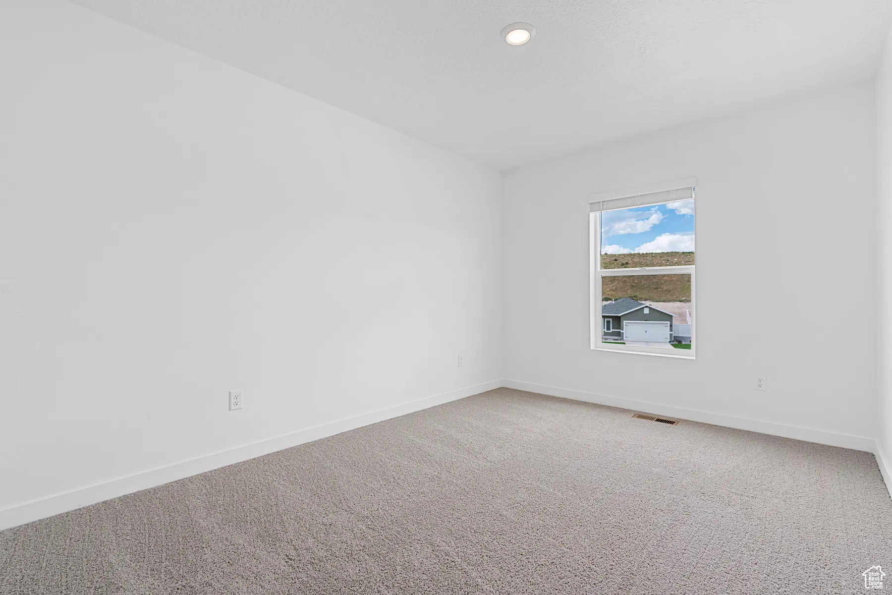 Unfurnished room featuring light carpet and baseboards
