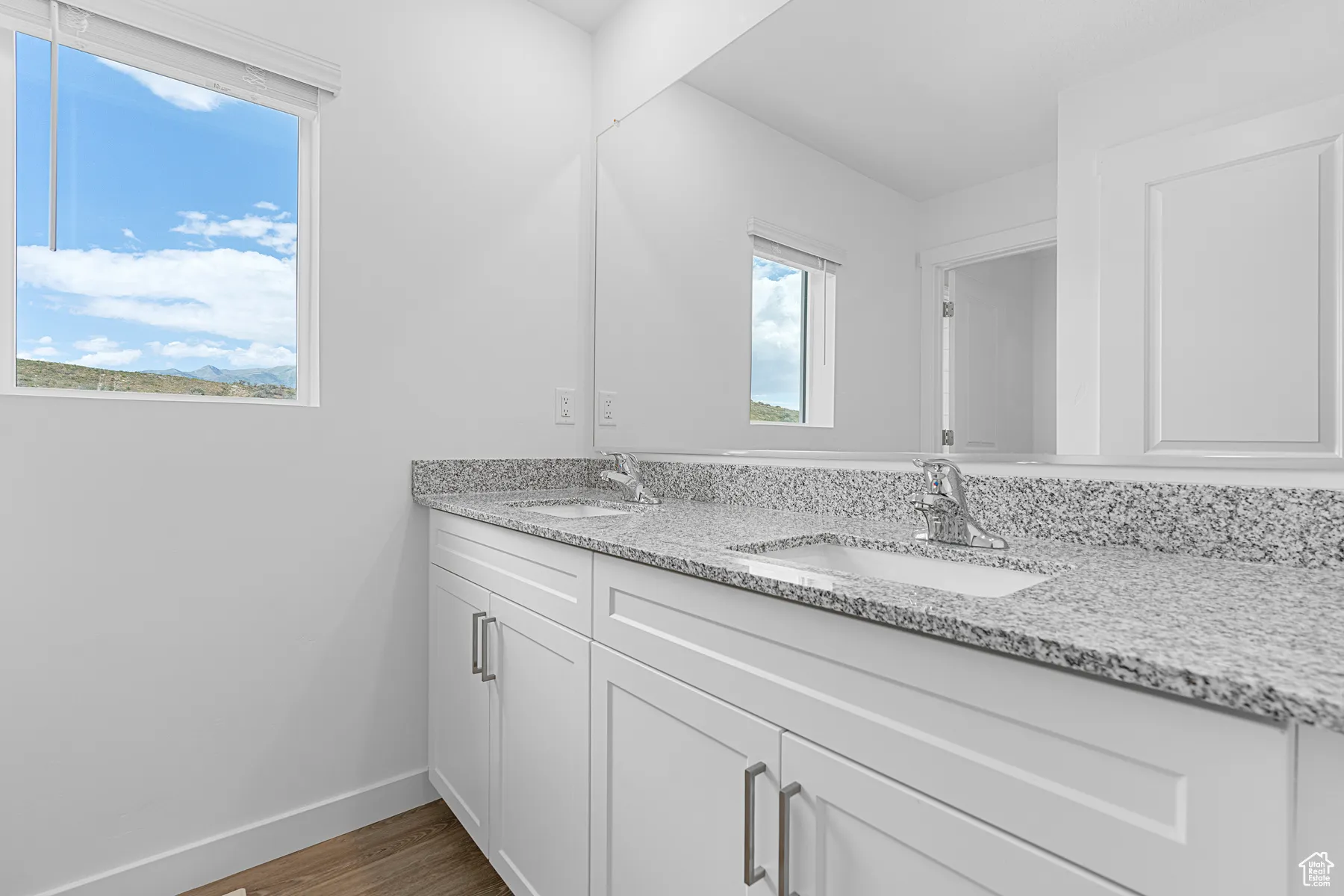 Full bath featuring double vanity and wood finished floors