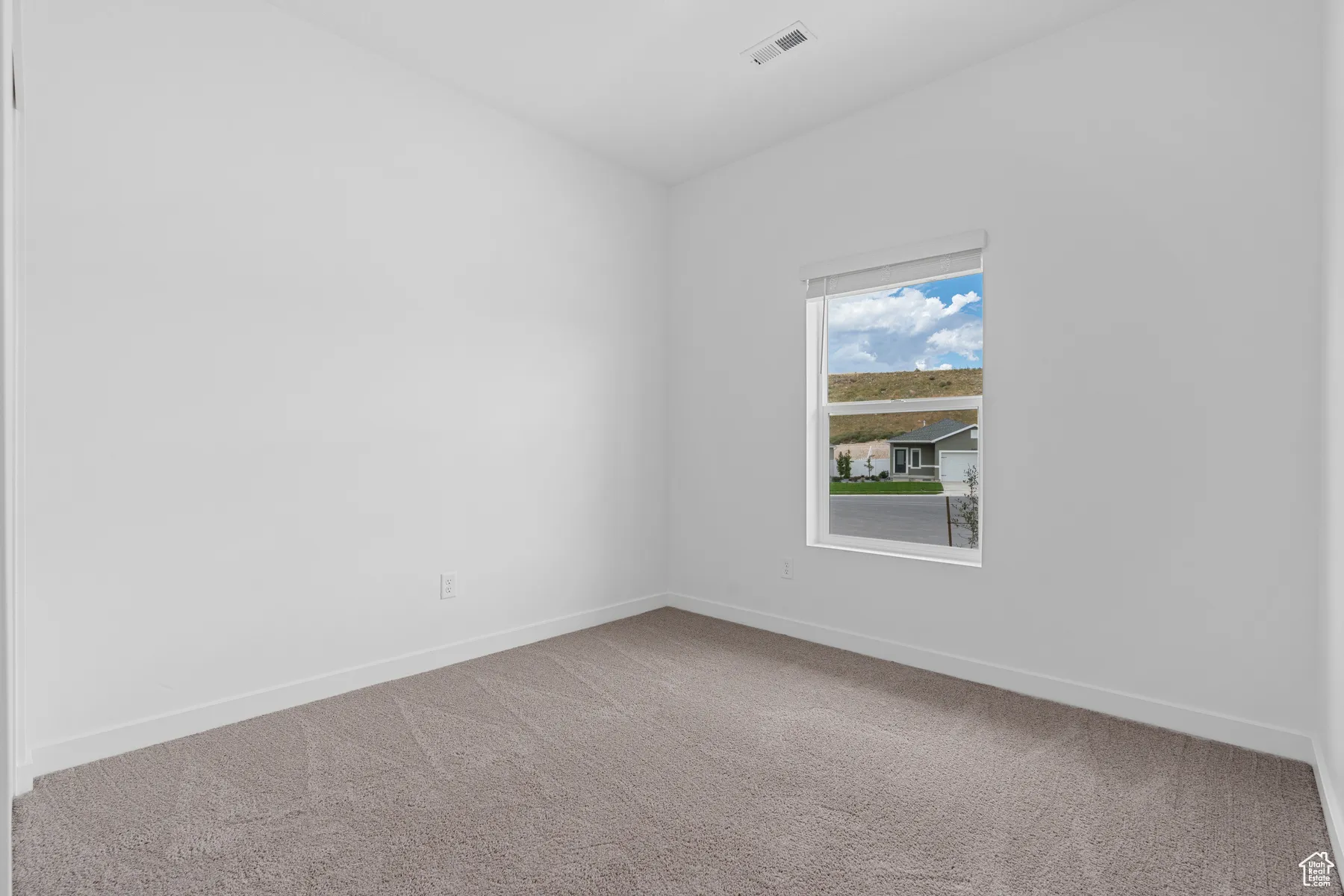 Carpeted empty room with baseboards