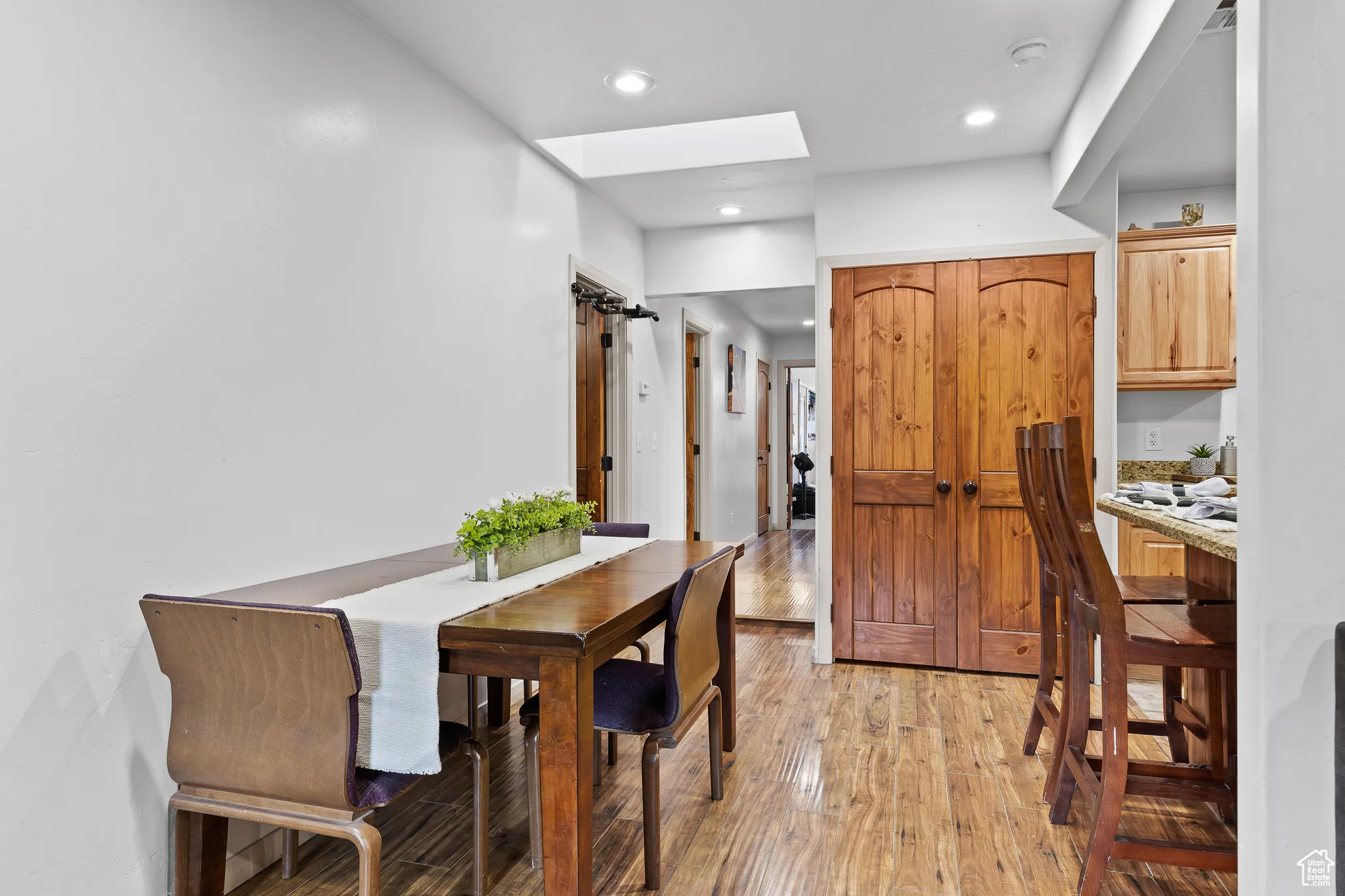 Dining area with light wood-style flooring and recessed lighting