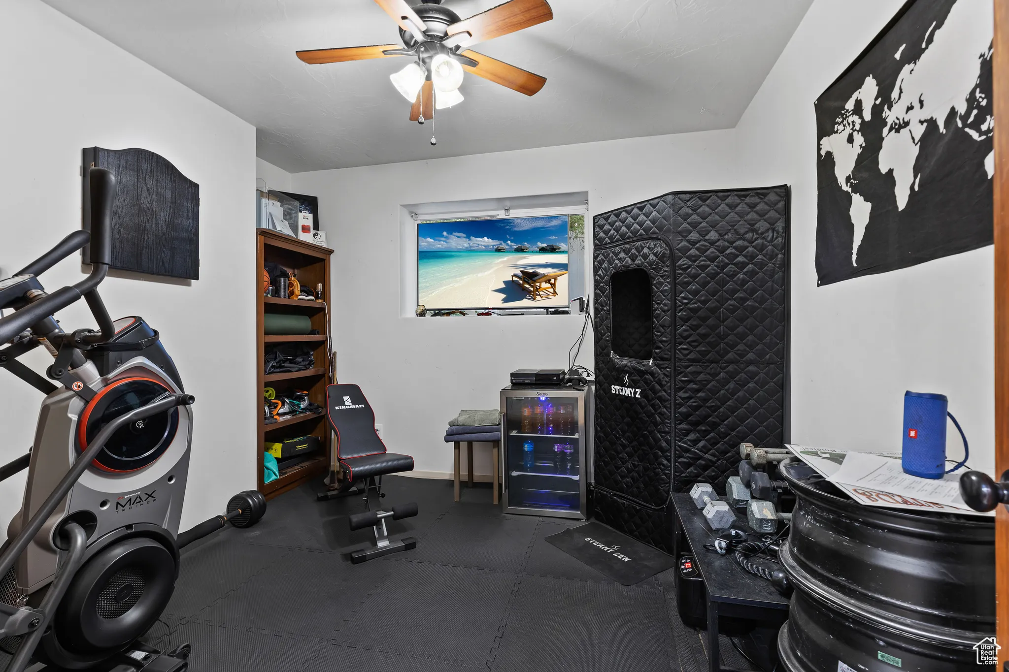 Workout room with a ceiling fan and baseboards