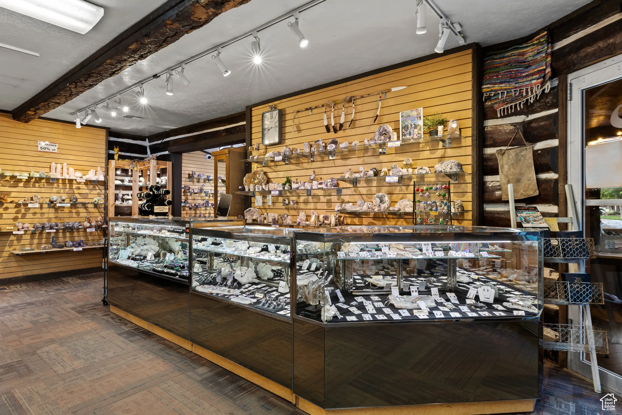 Community bar area with rail lighting, wood walls, and wood finished floors