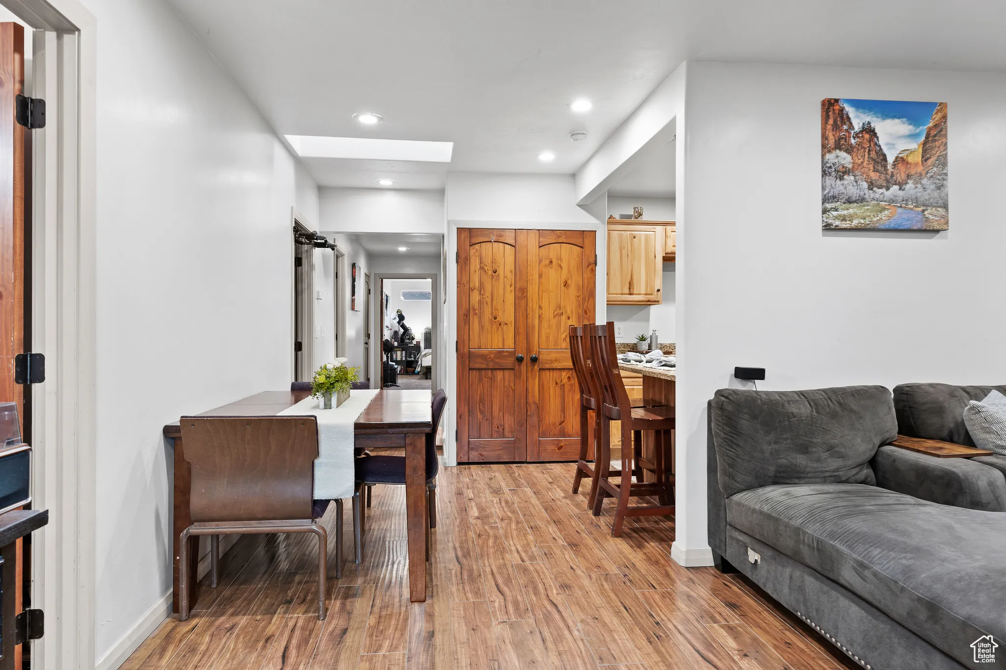 Living area with light wood finished floors, recessed lighting, and a skylight
