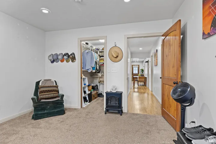 Living area with a wood stove, recessed lighting, and carpet