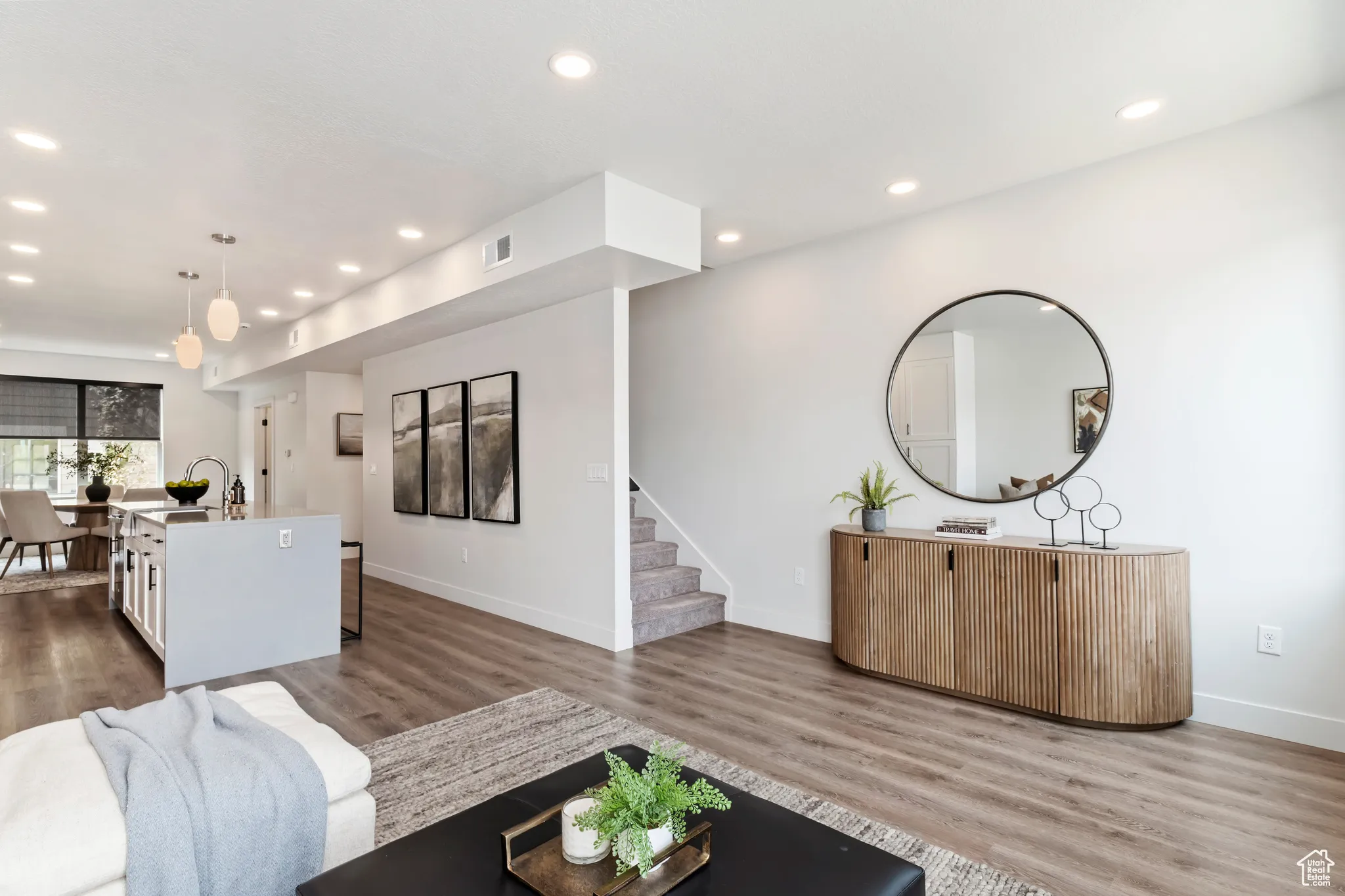 Living area with wood finished floors, recessed lighting, and stairs