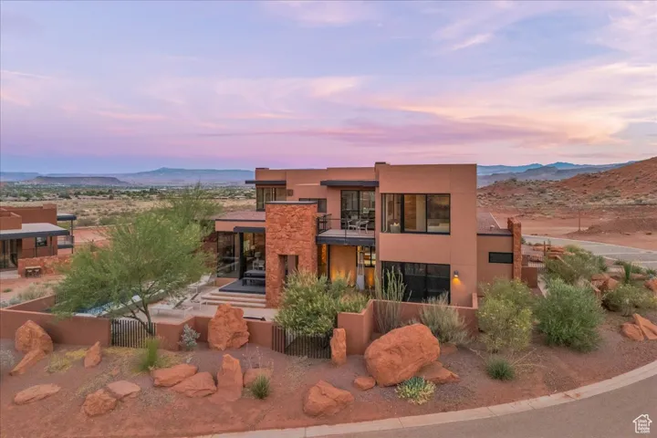 Rear view of property featuring a mountain view, stucco siding, and a balcony