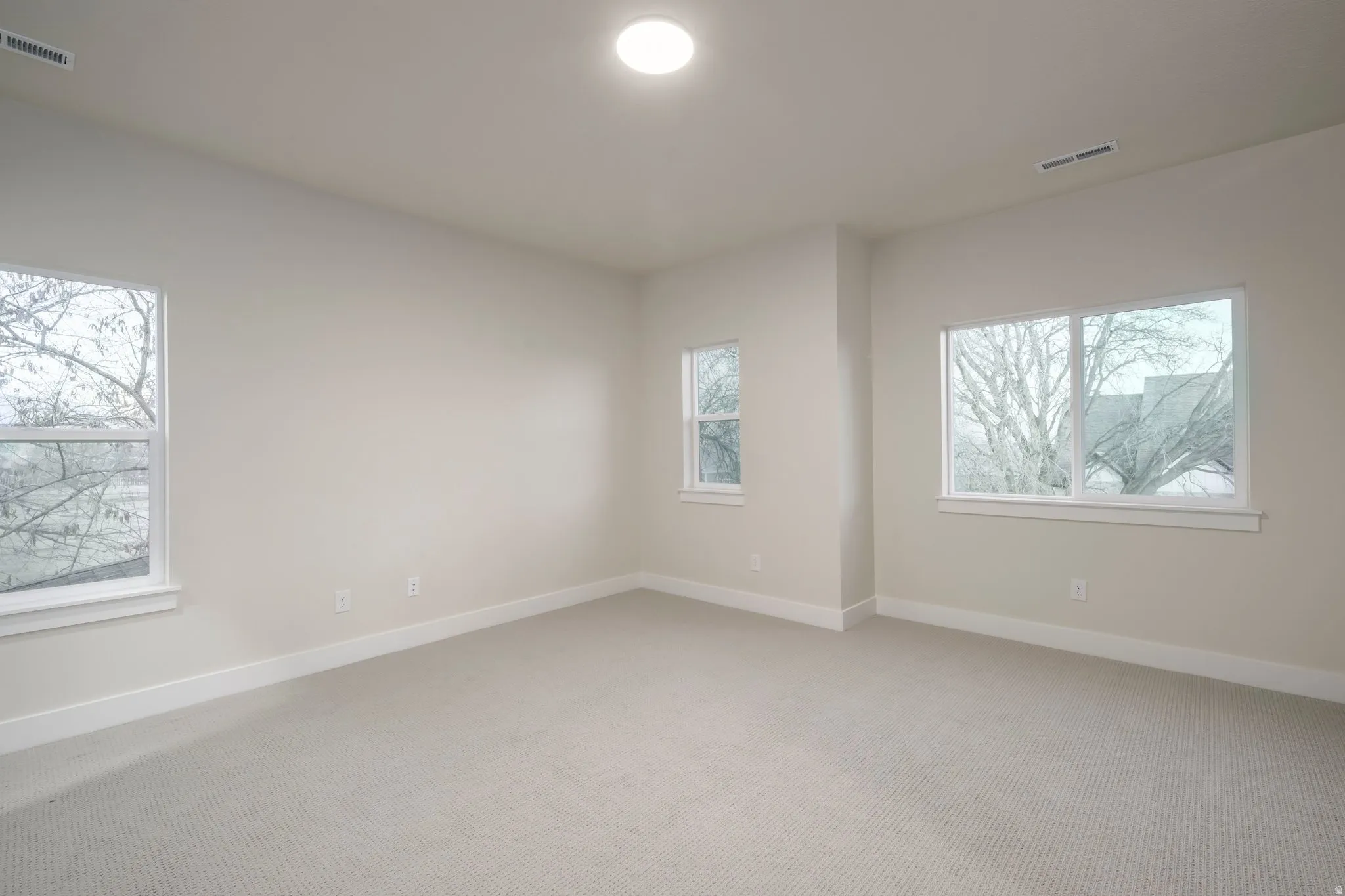 Carpeted spare room with baseboards