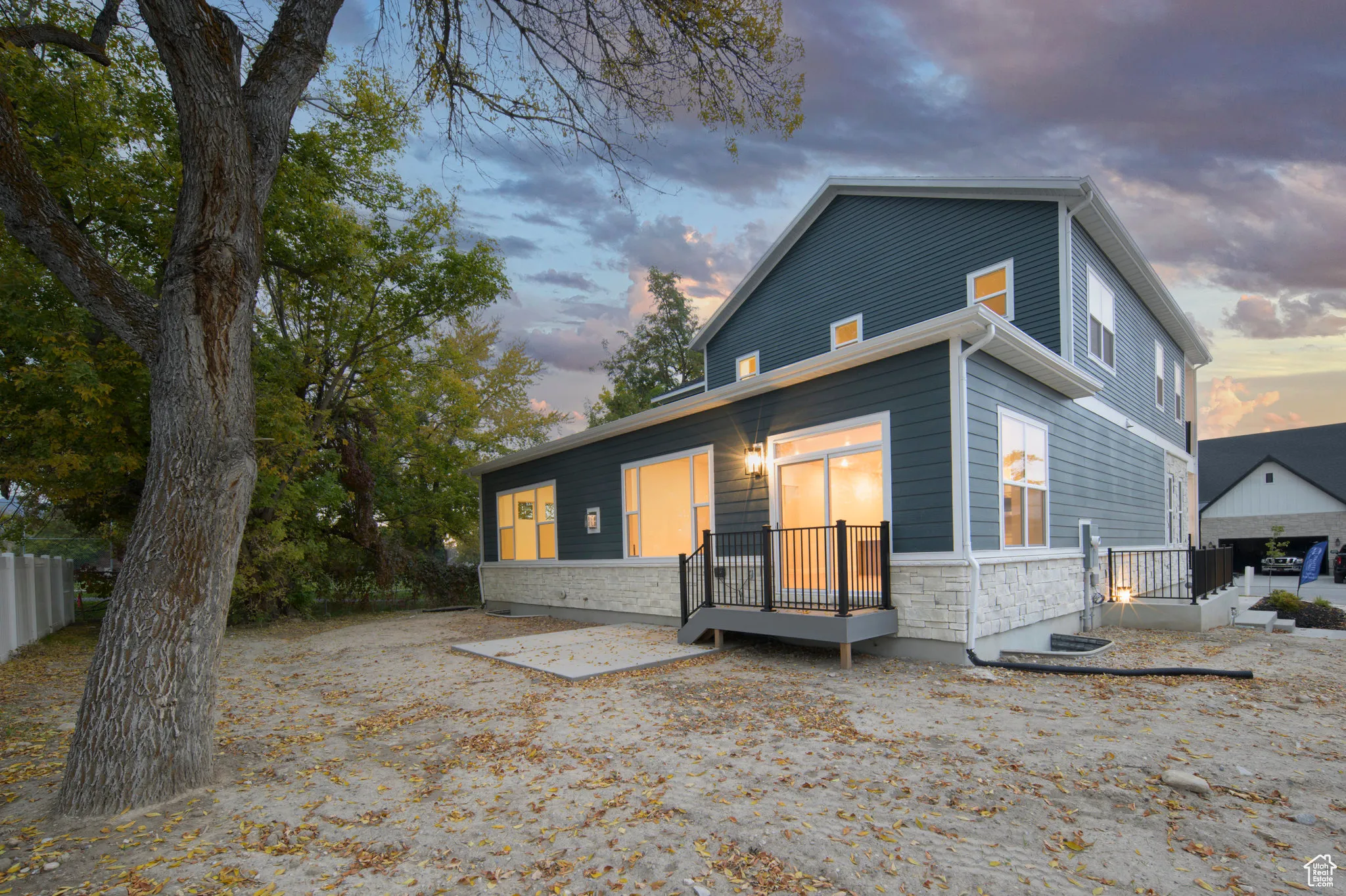 Rear view of property with stone siding and a deck