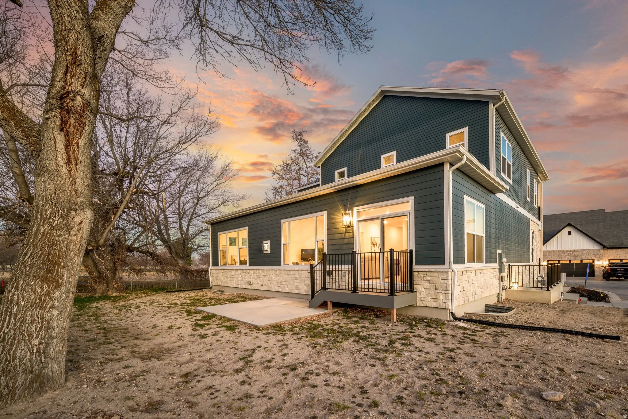 Back of house featuring stone siding and a wooden deck
