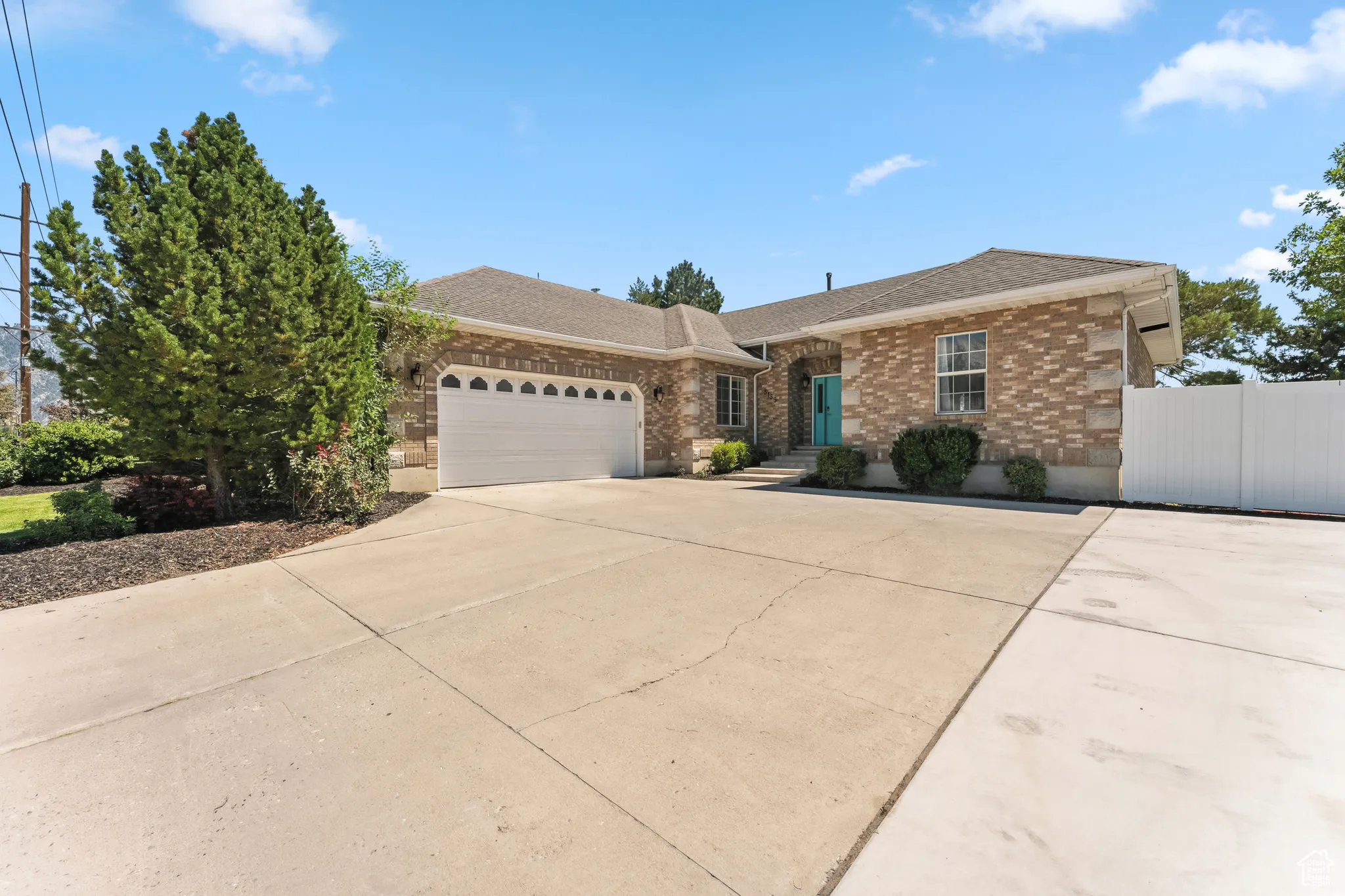 Ranch-style house featuring brick siding, concrete driveway, a garage, and a shingled roof