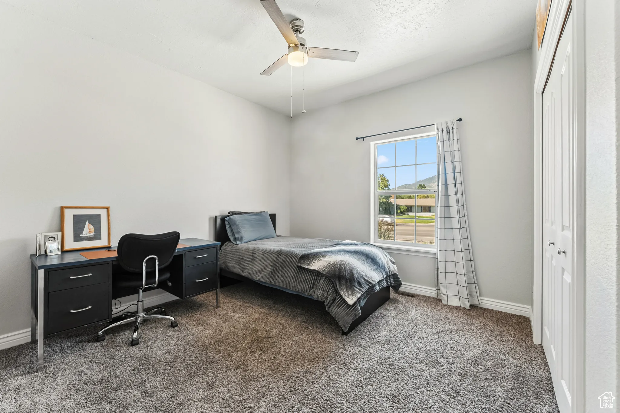 Bedroom featuring carpet, a closet, a ceiling fan, and an office area