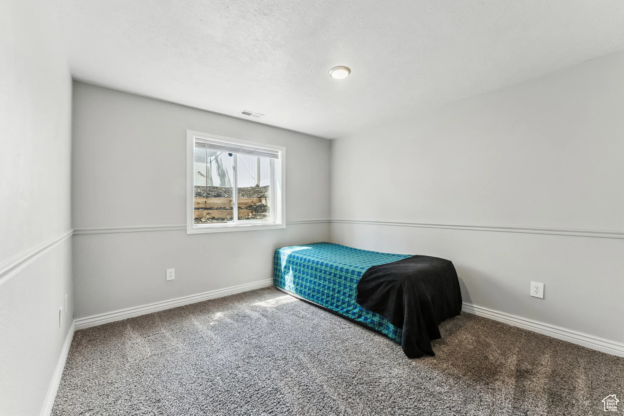 Unfurnished bedroom featuring carpet and a textured ceiling