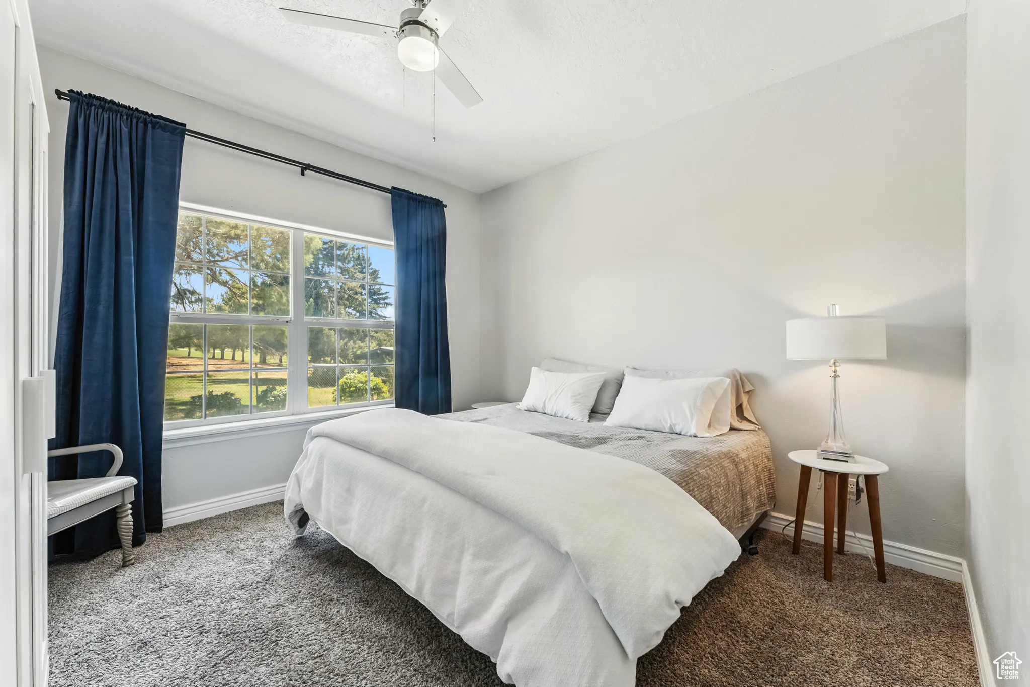 Carpeted bedroom with baseboards and ceiling fan