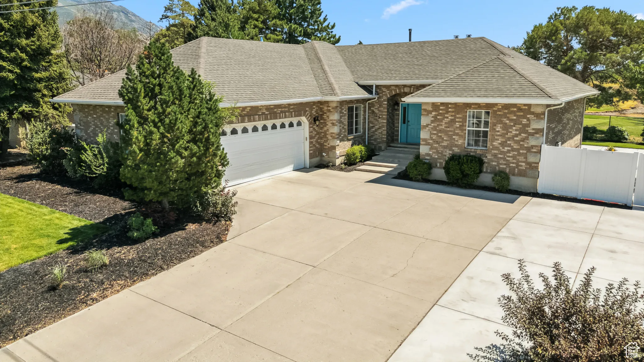 View of front of home featuring a garage, brick siding, concrete driveway, and a shingled roof