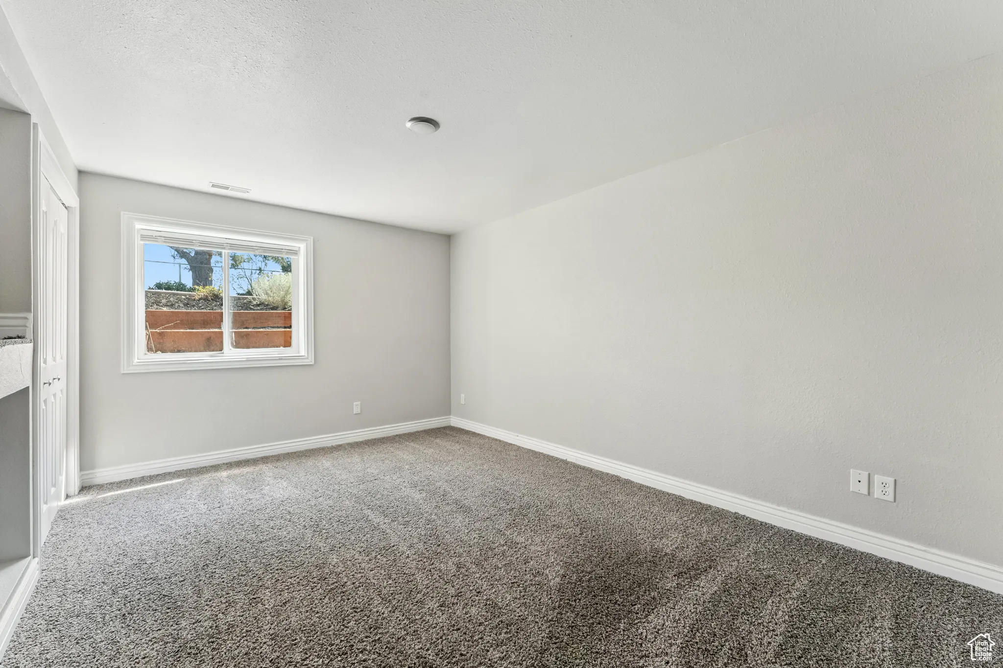 Carpeted empty room with baseboards