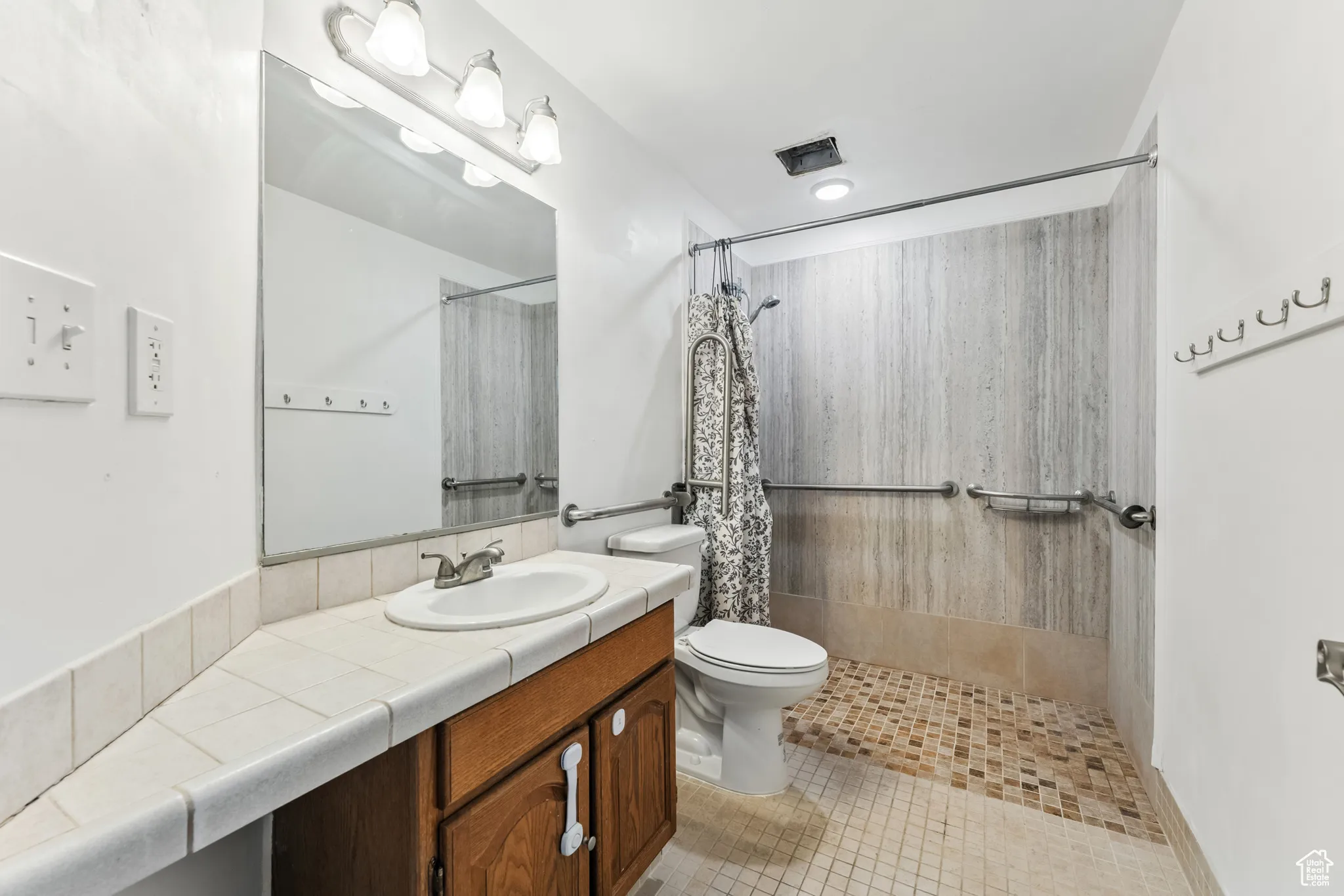 Bathroom with vanity, a shower with curtain, and tile patterned floors