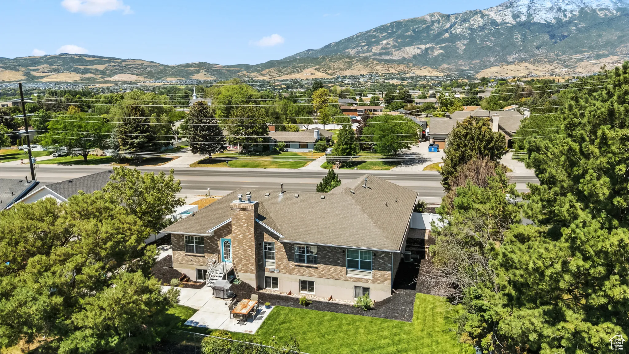 Aerial view of property and surrounding area featuring a mountain backdrop