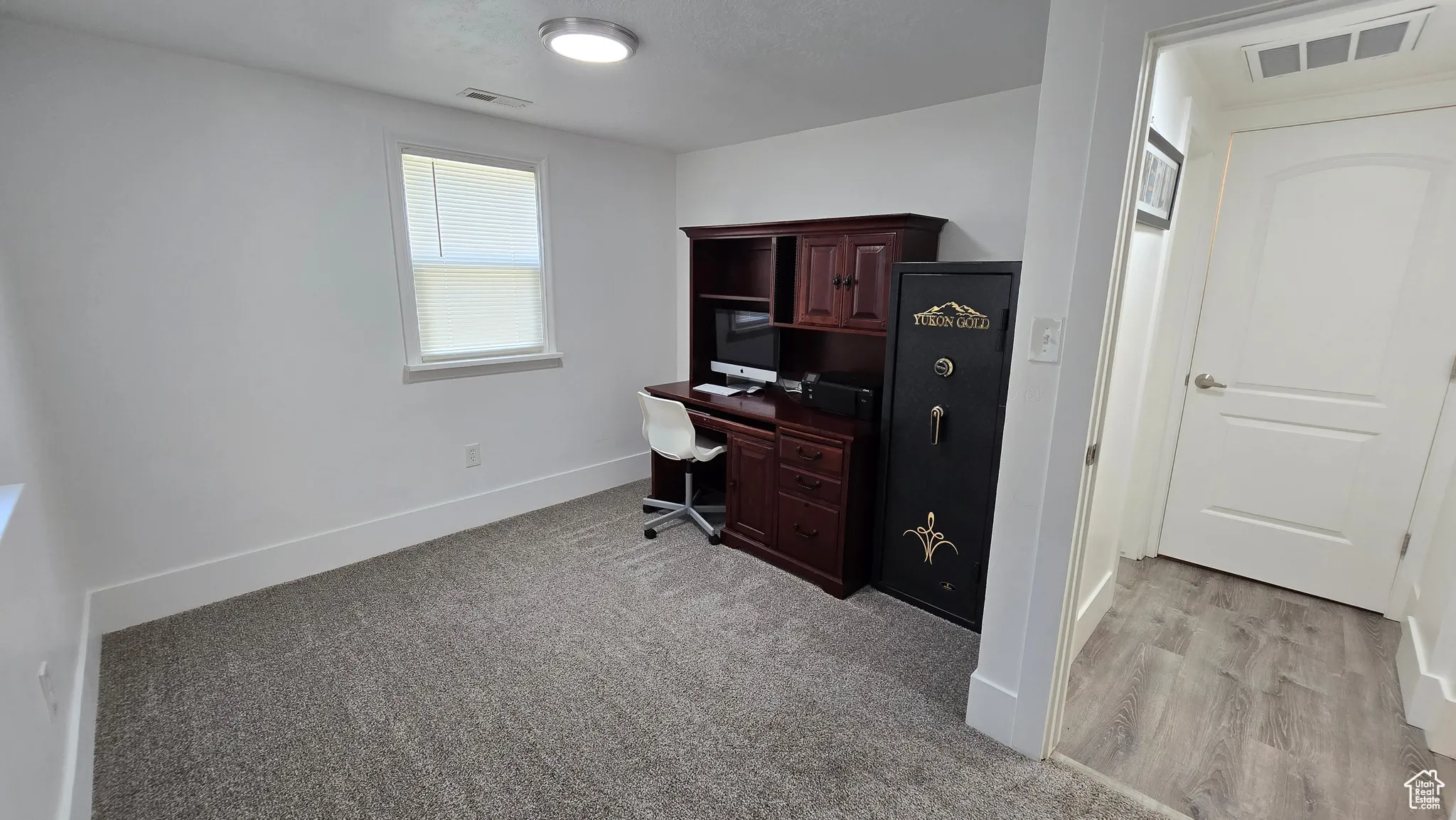 Office area with light carpet and a textured ceiling