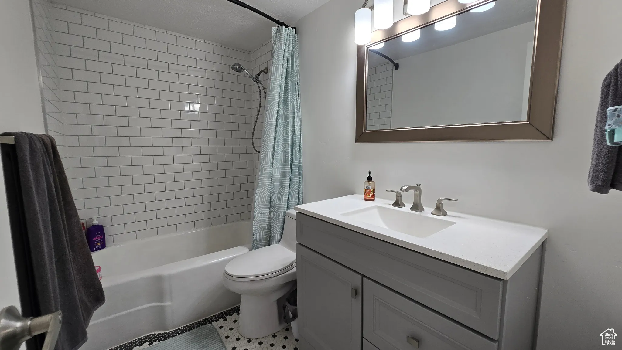 Bathroom with vanity and shower / bath combo with shower curtain