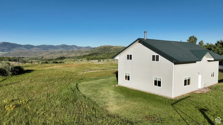 View of home's exterior with a yard and a mountain view