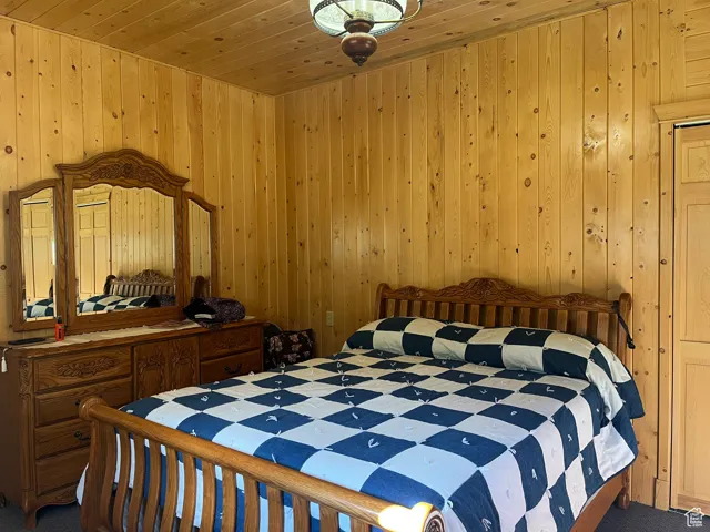 Bedroom with wooden ceiling and wooden walls