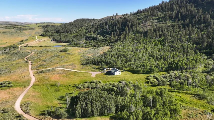 View of property location featuring a heavily wooded area and a water and mountain view