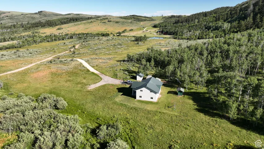 Aerial view of property's location featuring a water and mountain view and a heavily wooded area