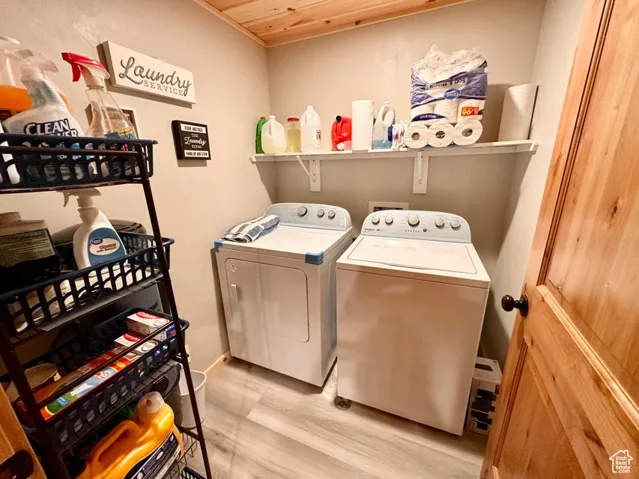Washroom with separate washer and dryer, light wood finished floors, and wood ceiling