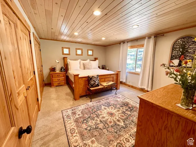 Bedroom featuring recessed lighting, wooden ceiling, light carpet, and ornamental molding