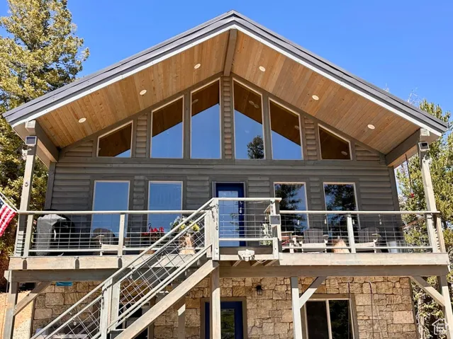 Rear view of property featuring stone siding