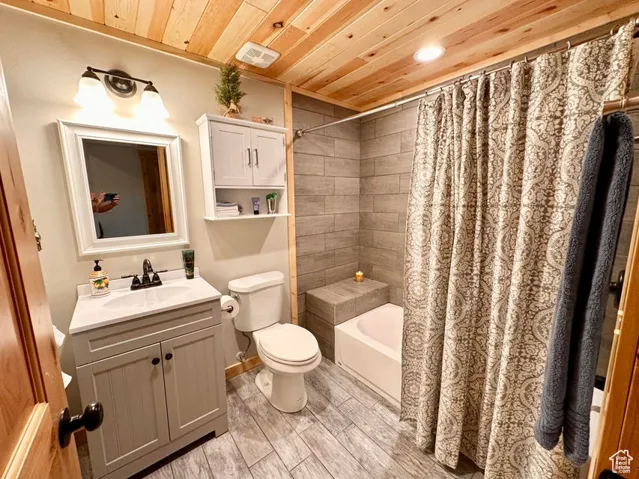 Full bath featuring wooden ceiling, vanity, shower / bath combo with shower curtain, wood finished floors, and recessed lighting